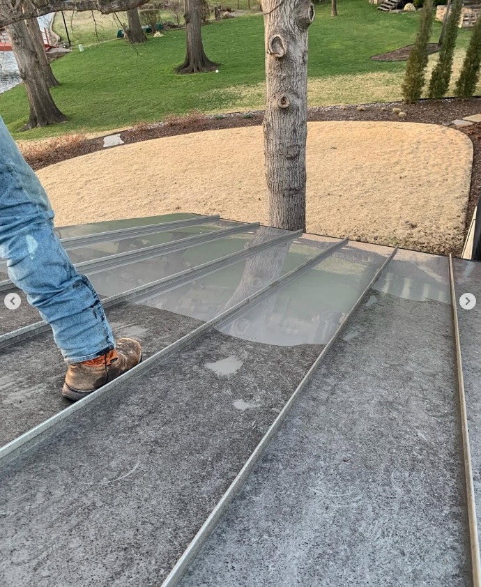 Metal roof during professional roof cleaning showing cleaned and untreated sections